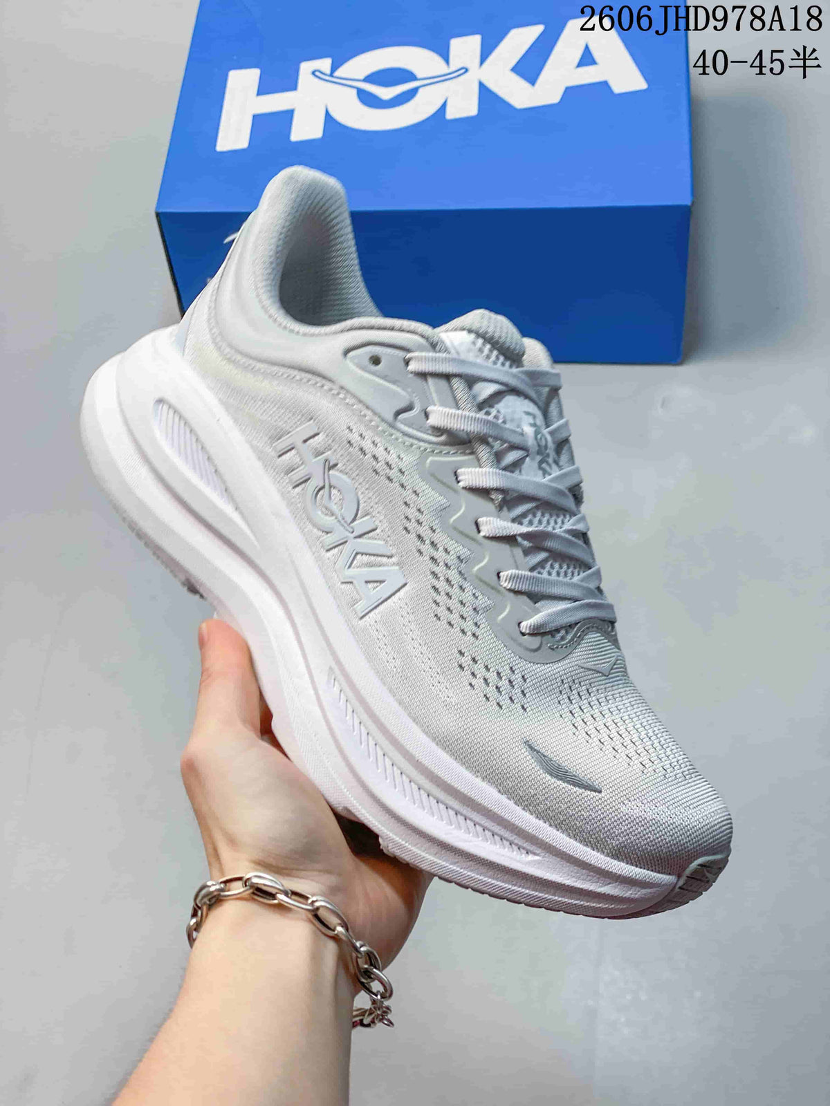 Angled side view of a light gray-white HOKA Bondi 9 shoe