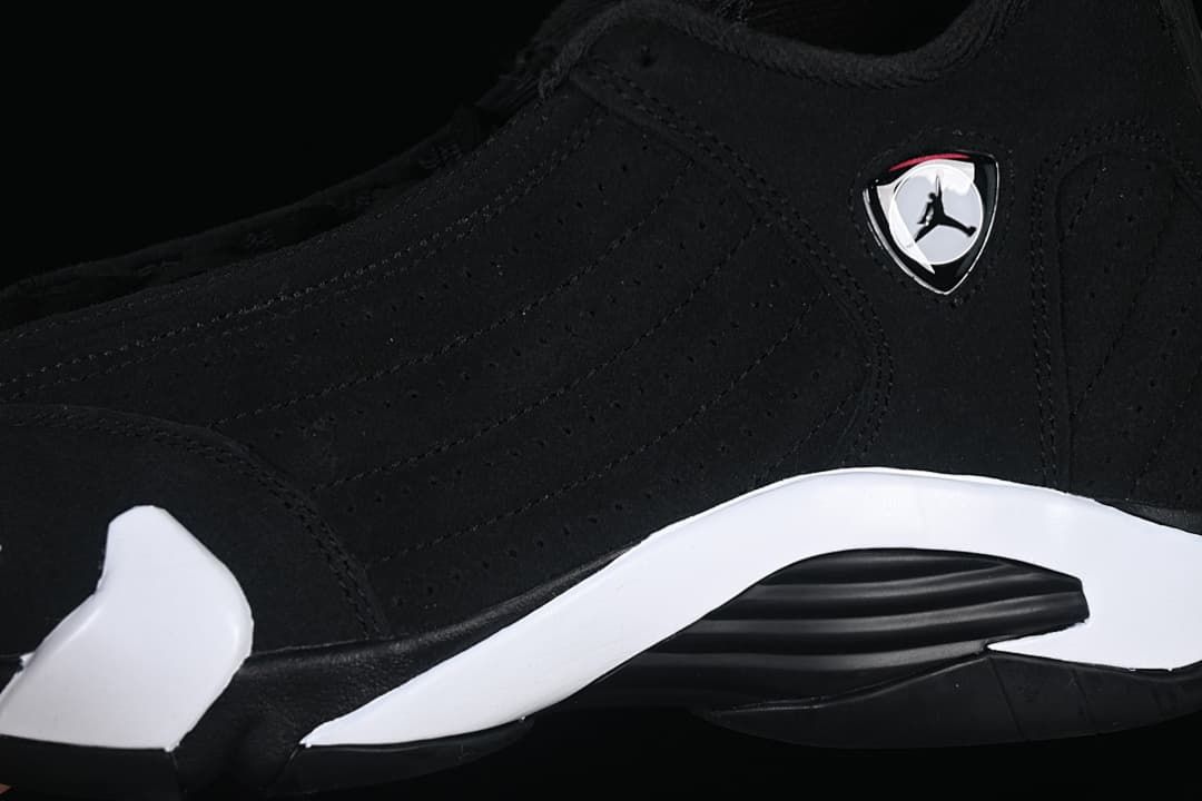 Close-up of the black upper, side emblem, and white midsole