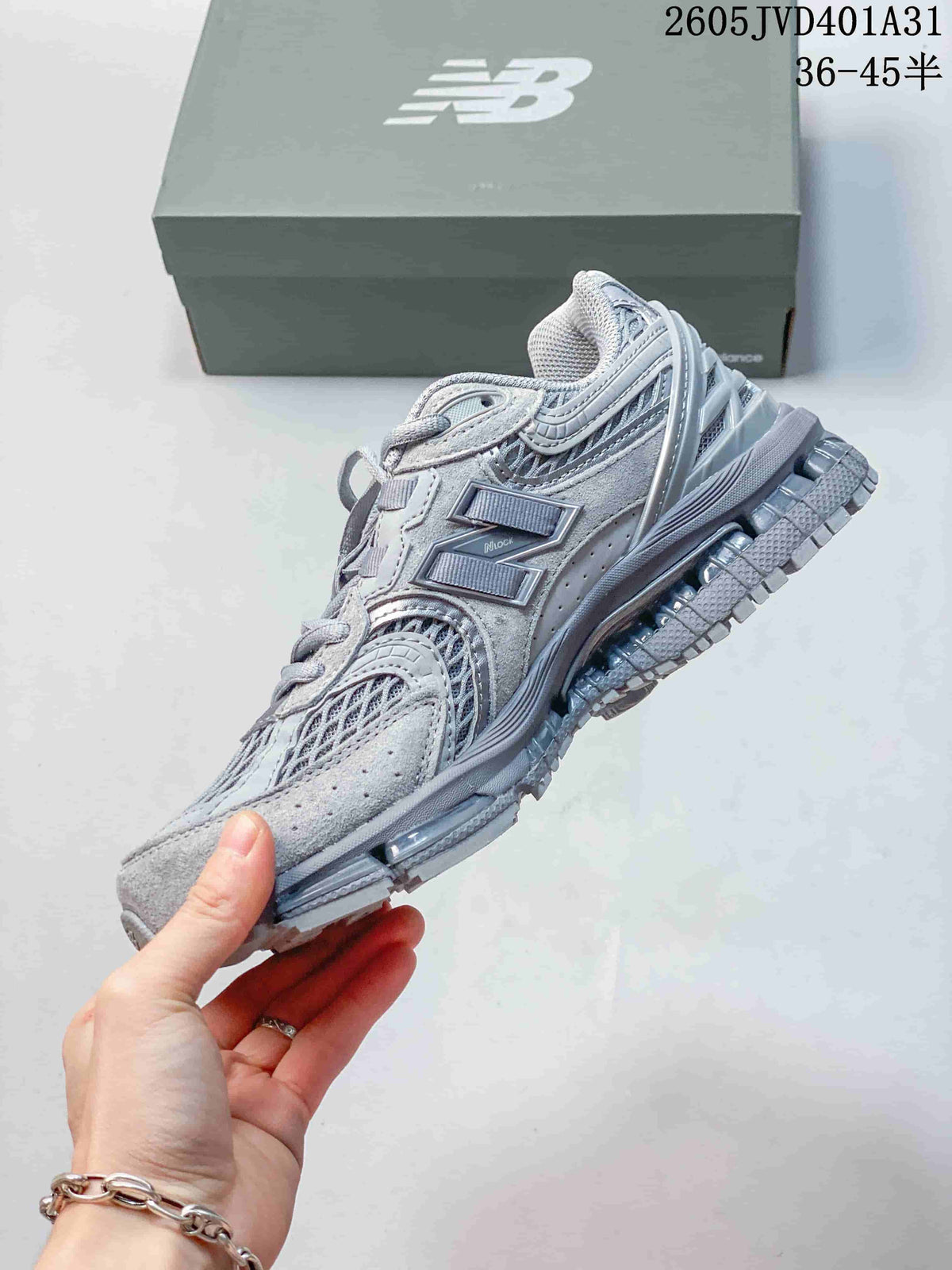 Side view of the silver-gray sneaker with layered panels and mesh.