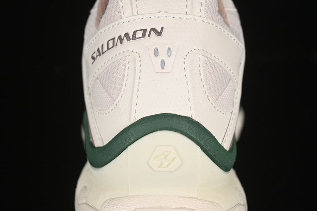 Rear view of the shoe with Salomon branding and a dark green heel accent.