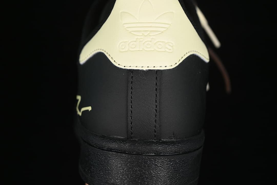 Rear view showing the cream heel tab, embossed Trefoil branding, and black heel.