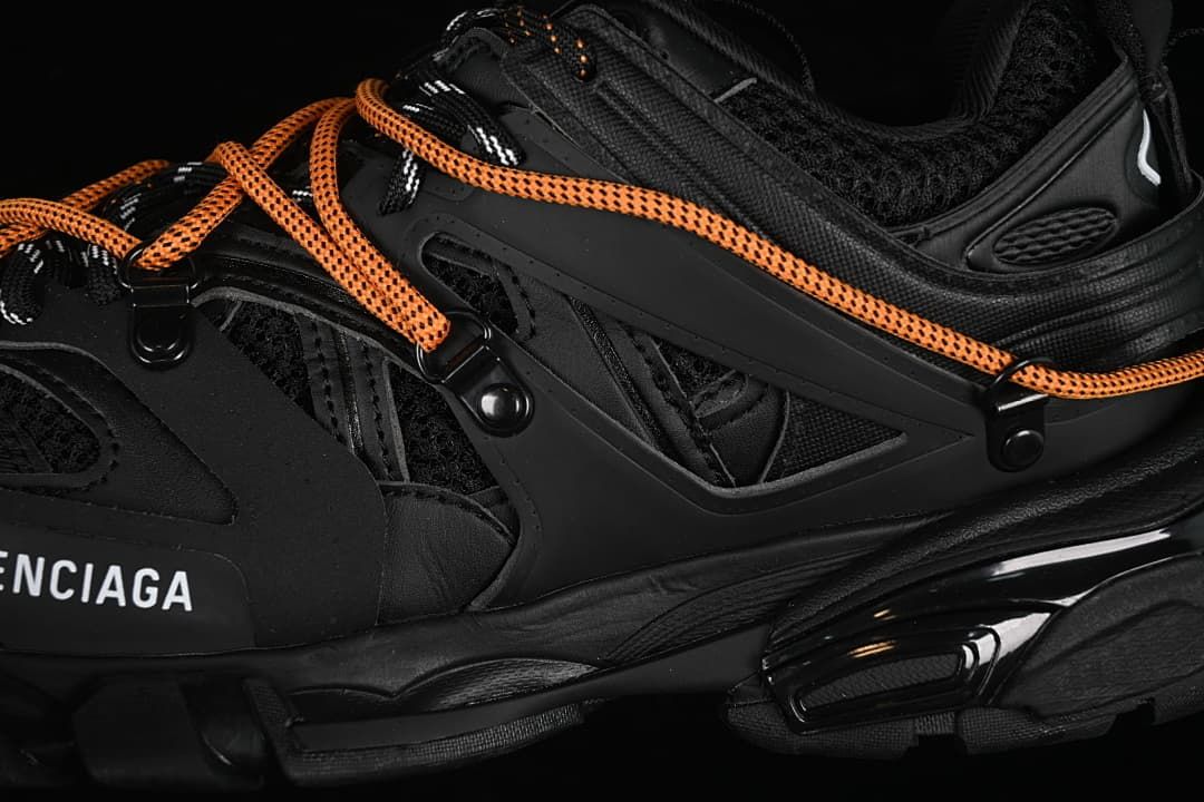 Close-up of layered side panels and orange laces.