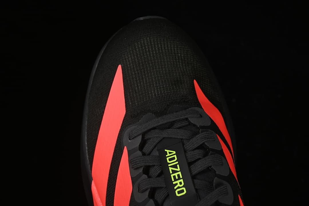 Top-down detail of the toe and lacing with coral-red side stripes