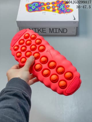 Underside view of the red slide showing multiple circular contact points across the outsole.
