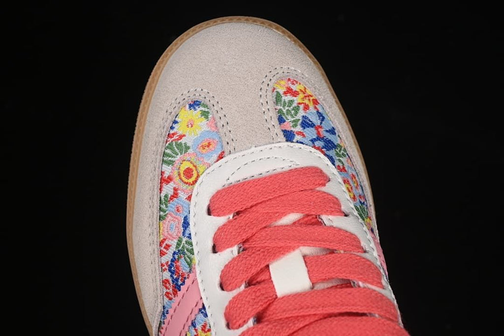 Top view of floral toe panels, light-colored overlays and coral laces.