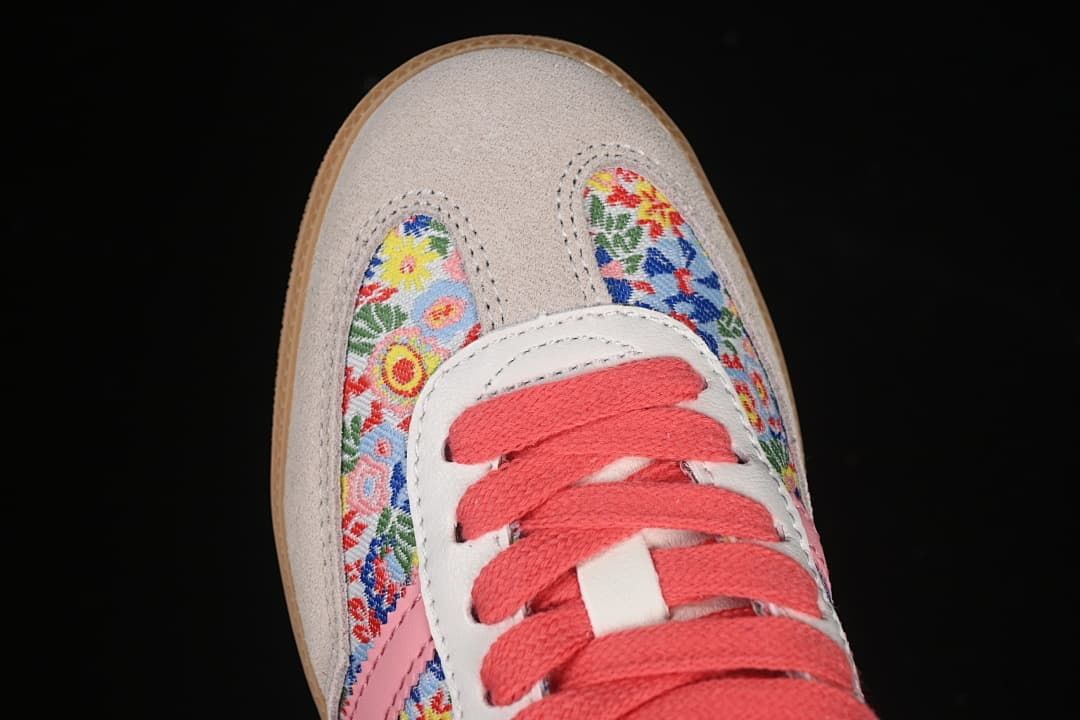 Top view of floral toe panels, light-colored overlays and coral laces.