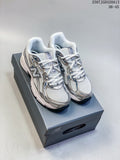 Pair of silver, white, and navy New Balance 740 sneakers displayed on a shoebox.
