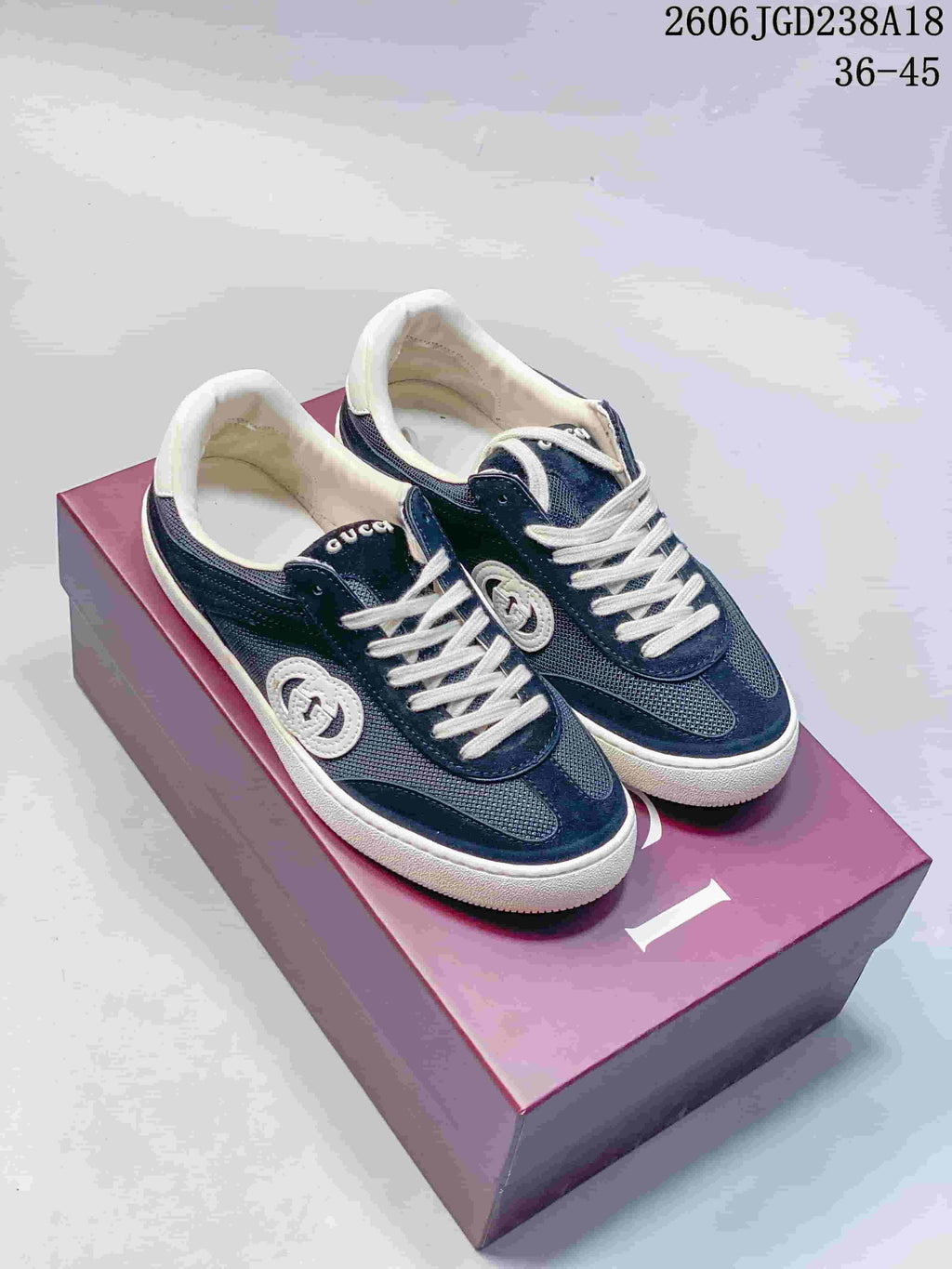 Navy and white low-top sneakers shown from above on a box