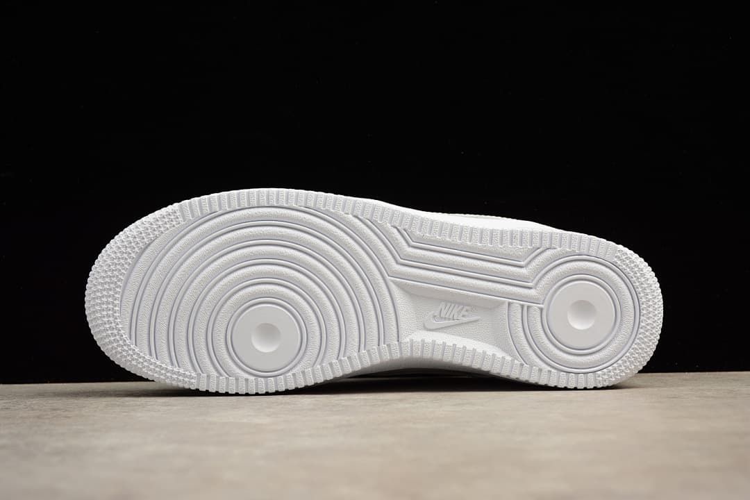 Underside of the white sneaker showing the circular outsole tread.