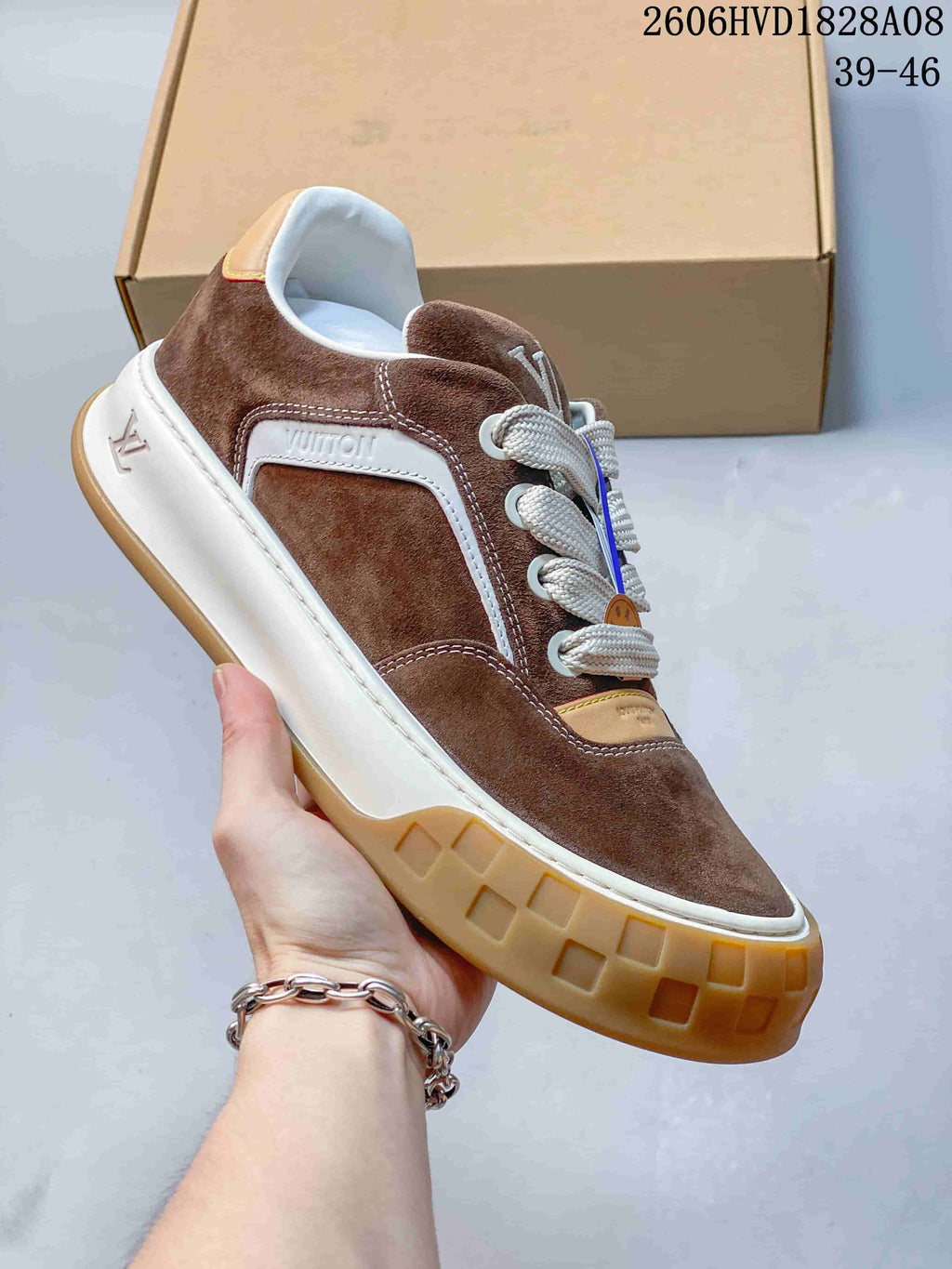 Angled side view of a brown low-top sneaker with white trim and a gum-colored outsole