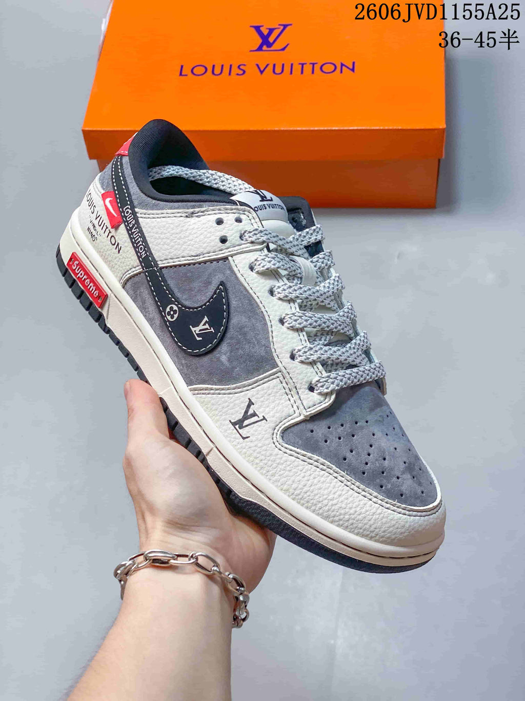 Close view of a gray and white low-top sneaker with a patterned side panel and dark overlays