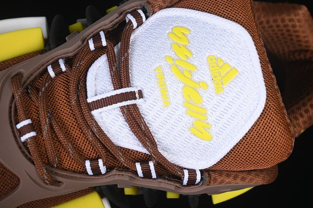 Close-up of the tongue with branded lettering and brown-and-white laces