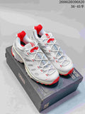 Pair of white and gray Salomon XT-4K shoes with red accents, shown on a Kith-branded box