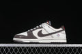 Side view of a cream and brown Nike SB Dunk Low sneaker with collaboration-style heel branding