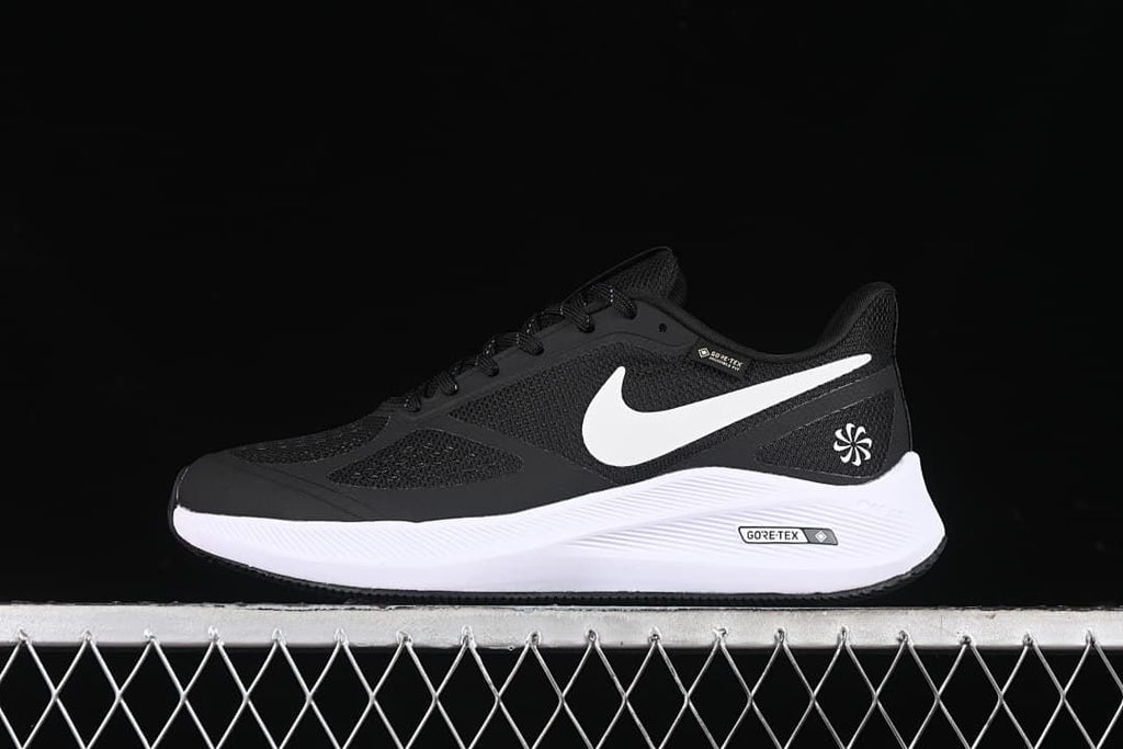 Side view of the black and white shoe against a dark background