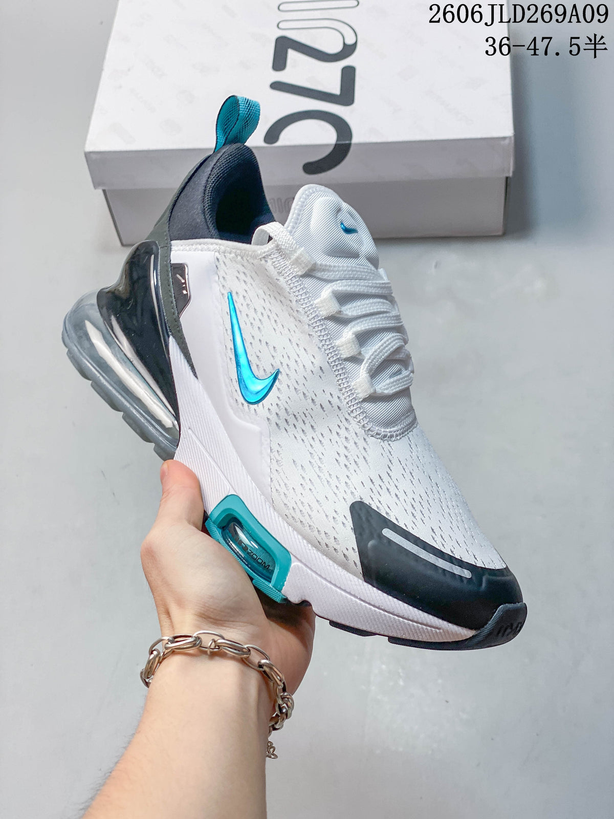 Side view of a white Nike Air Max 270 sneaker with teal branding and a visible heel unit