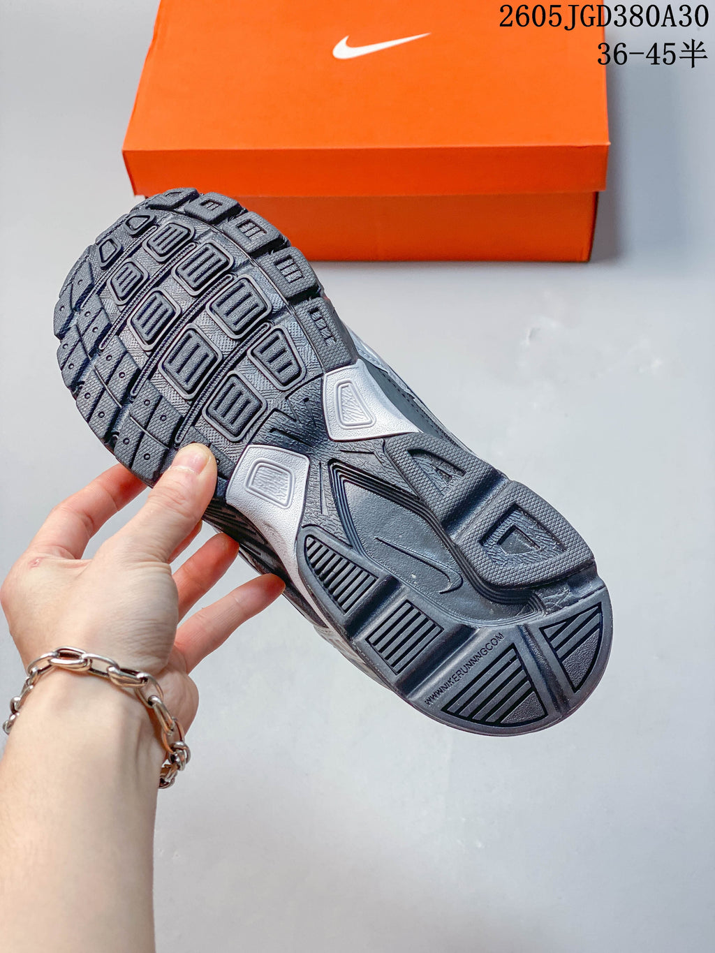 Close-up of the patterned outsole on a charcoal and silver Nike Initiator sneaker