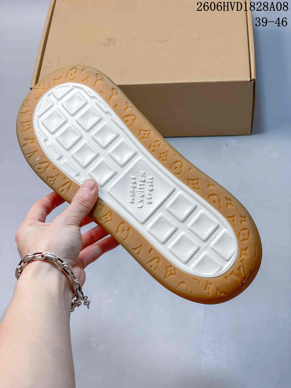 Underside of a sneaker showing a white tread center and gum-colored outsole