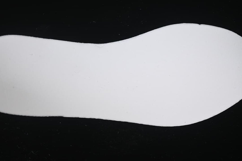 Plain white sneaker-shaped insert shown against a dark background.