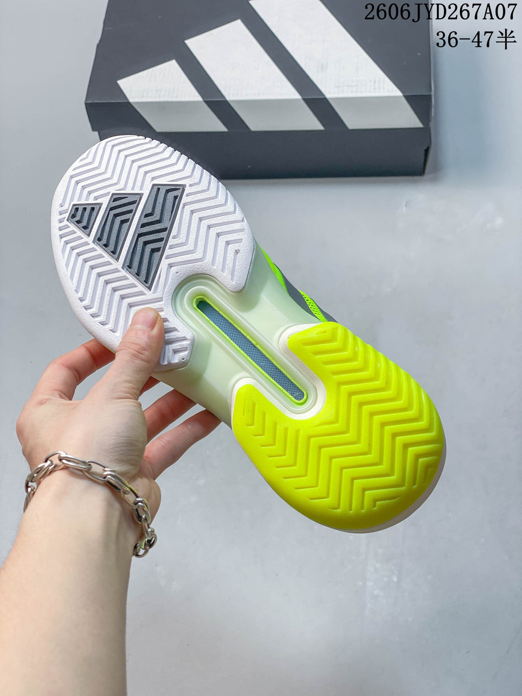 Underside of the tennis shoe showing a white and yellow patterned outsole.