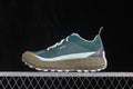 Side profile of green, gray, tan, and white norda 001 sneakers on a chain-link platform.