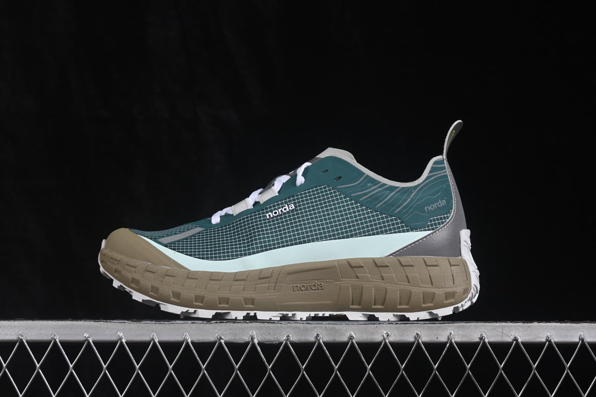 Side profile of green, gray, tan, and white norda 001 sneakers on a chain-link platform.