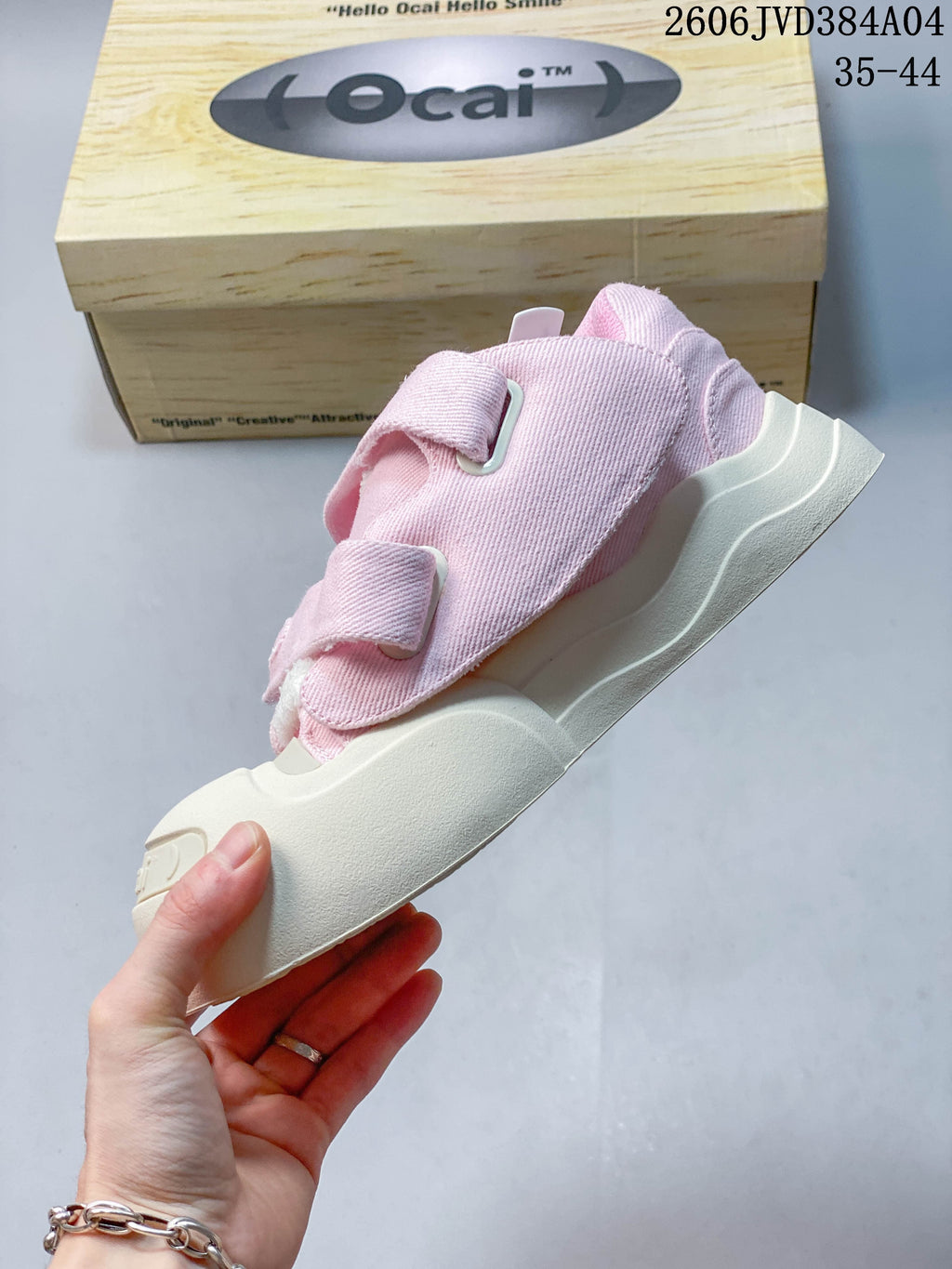 Side view highlighting the pink upper, hook-and-loop straps, and thick off-white sole.