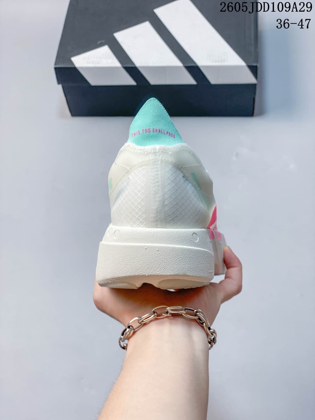 Rear view showing the white heel structure, teal tongue accent, and raised sole.