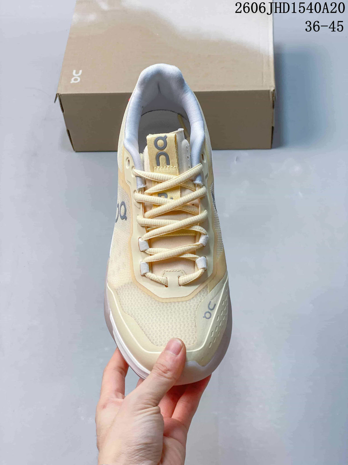 Top-down view of the cream lace-up On tennis shoe