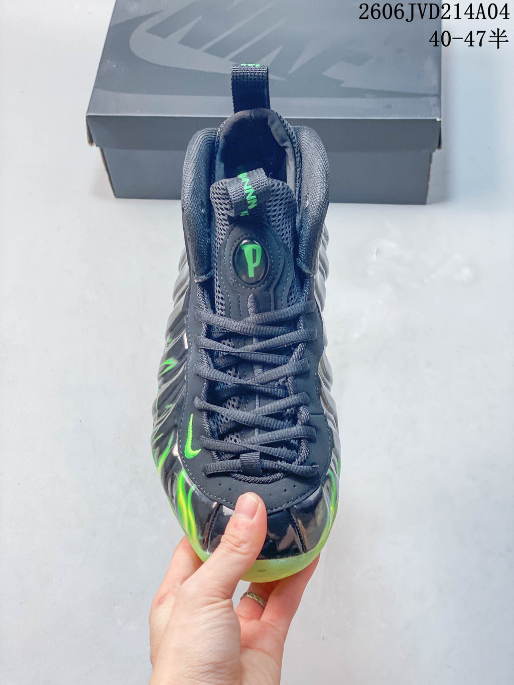 Top view showing the laces, tongue, and green accents on a gray Nike basketball shoe.