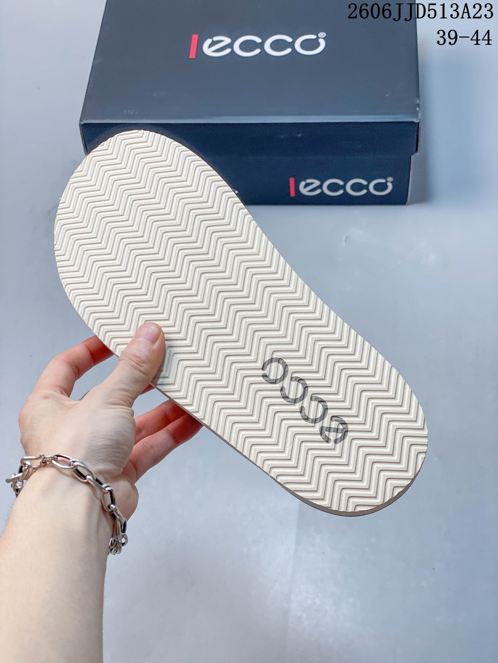 Underside of a slide sandal showing a light-colored zigzag tread pattern