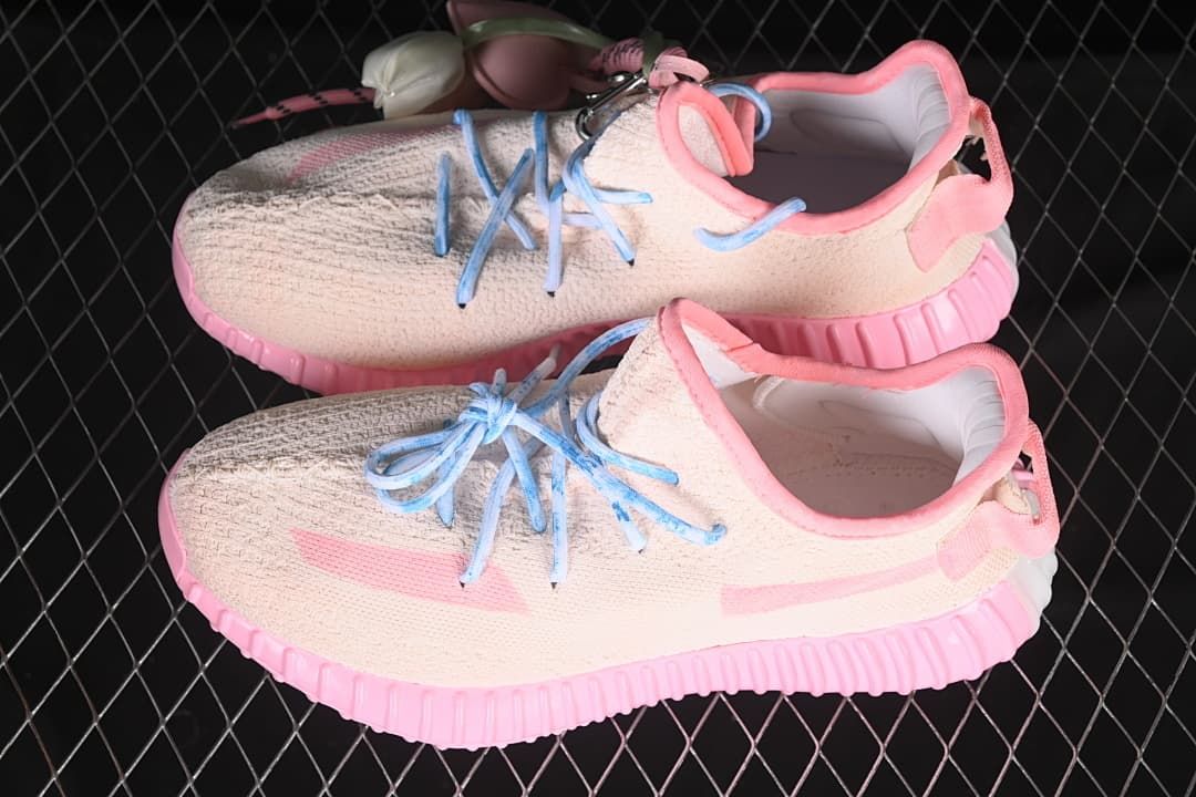 Pair of pale pink sneakers with blue laces and decorative charms.