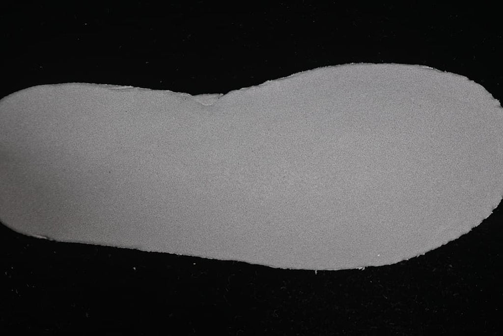 Plain side of a light-colored shoe insole