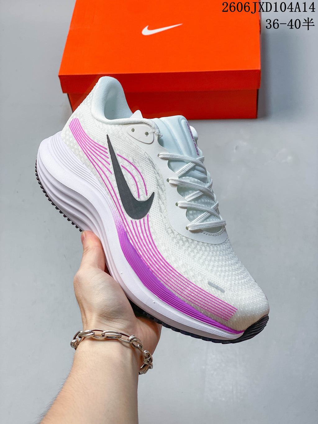 Close-up side view of a white Nike Journey Run running shoe with purple accents, a dark Swoosh, and thick white midsole.