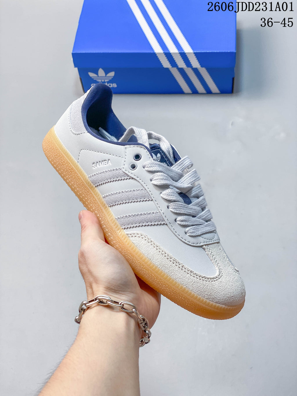 Side view showing the Samba name, gray stripes, textured toe panel, and gum-colored sole.