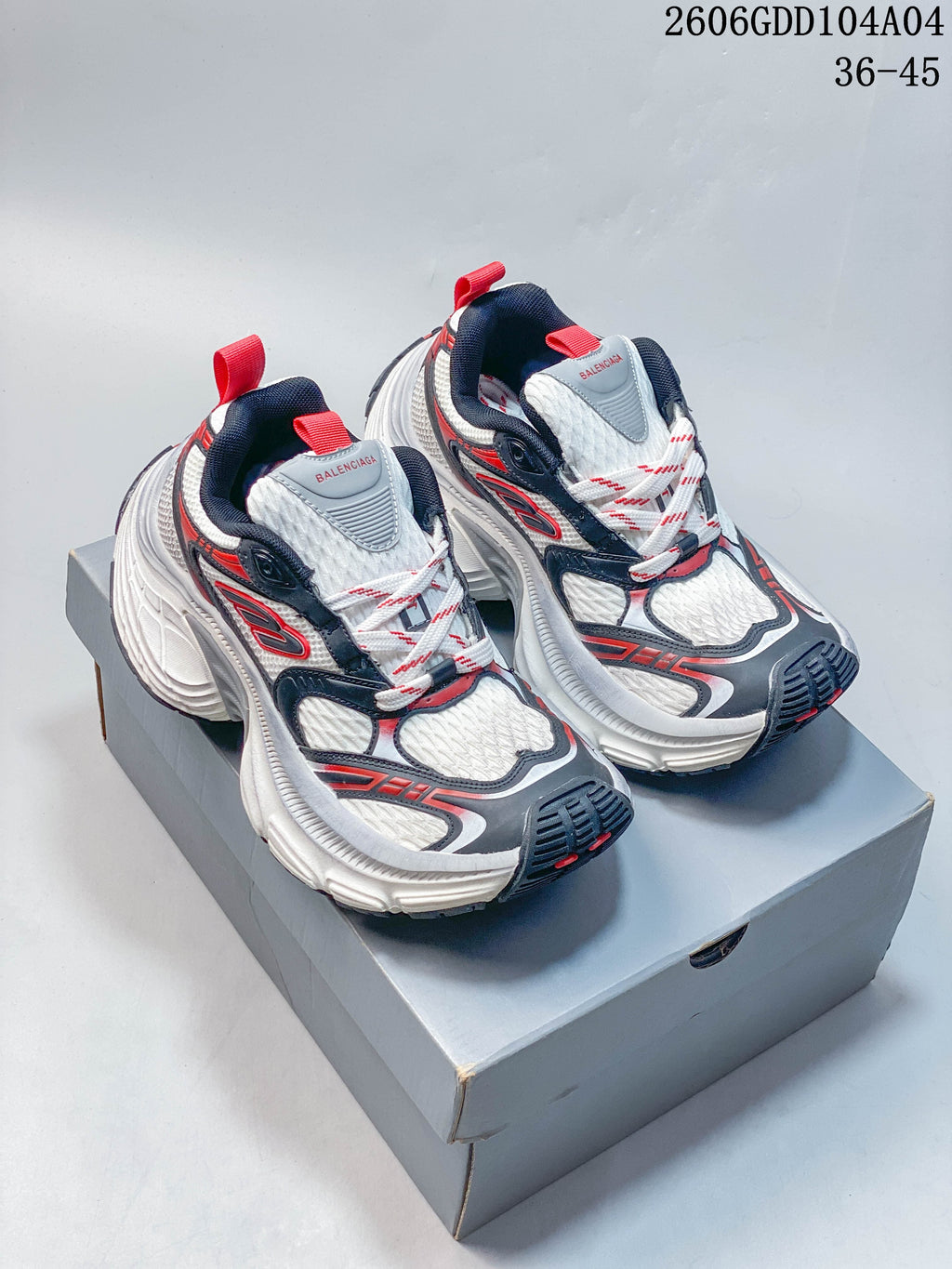 Pair of white, grey, navy and red Balenciaga Hamptons sneakers on a shoebox