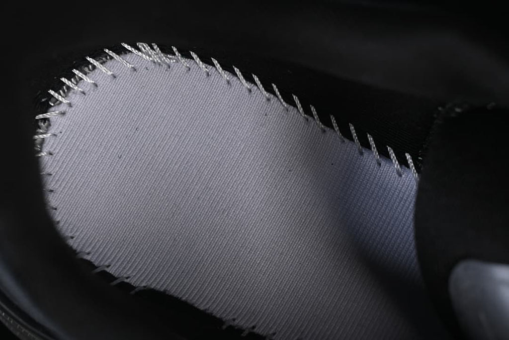 Close-up of a light-colored fabric section with stitched edges.