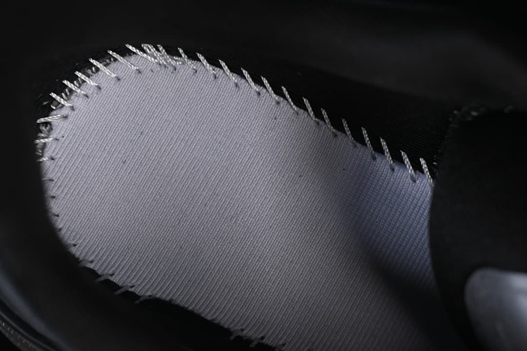 Close-up of a light-colored fabric section with stitched edges.