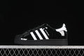 Side view of a black adidas Superstar II sneaker with white stripes and a black outsole