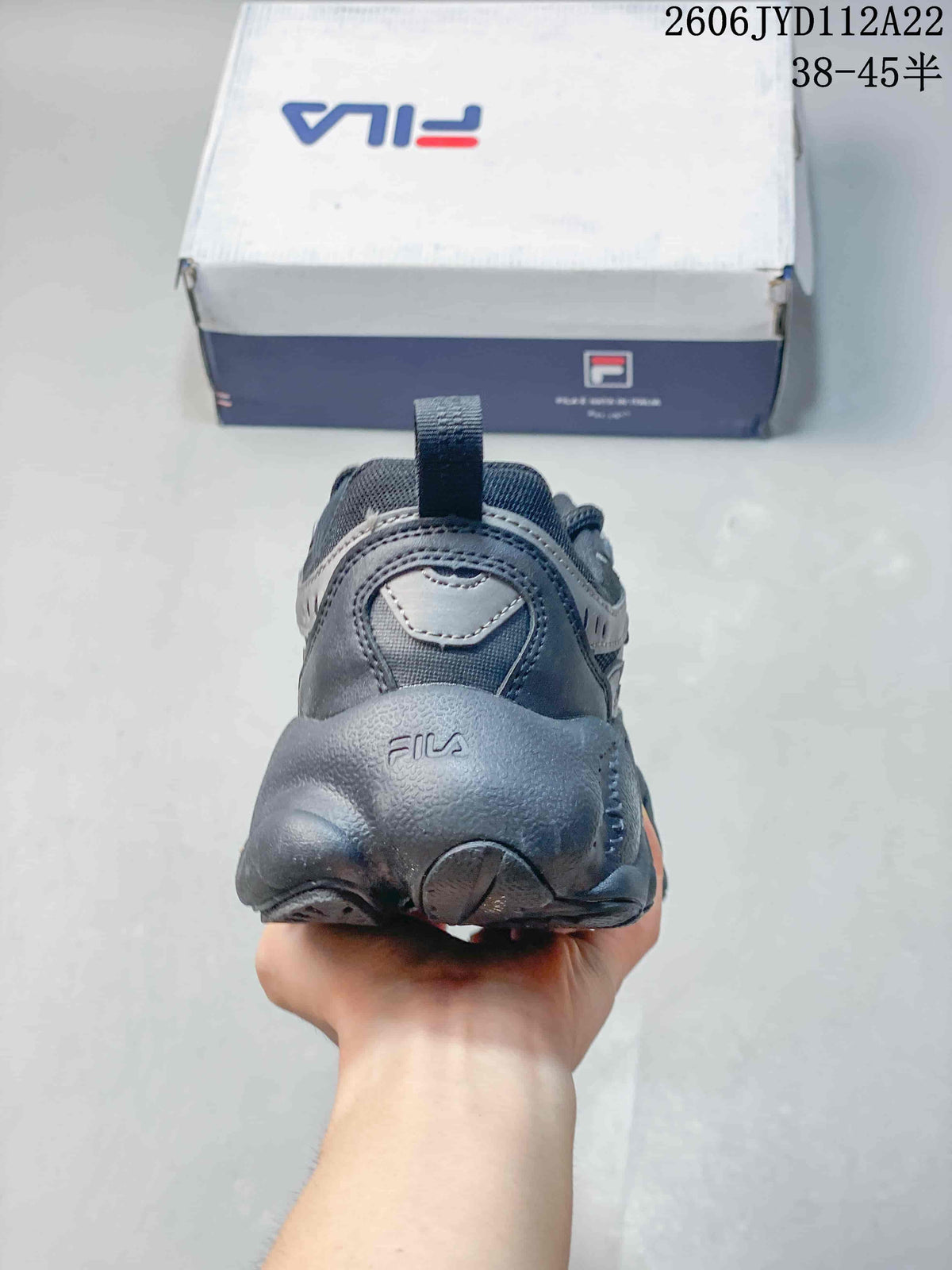 Rear view of a gray FILA sneaker showing the heel and sculpted sole