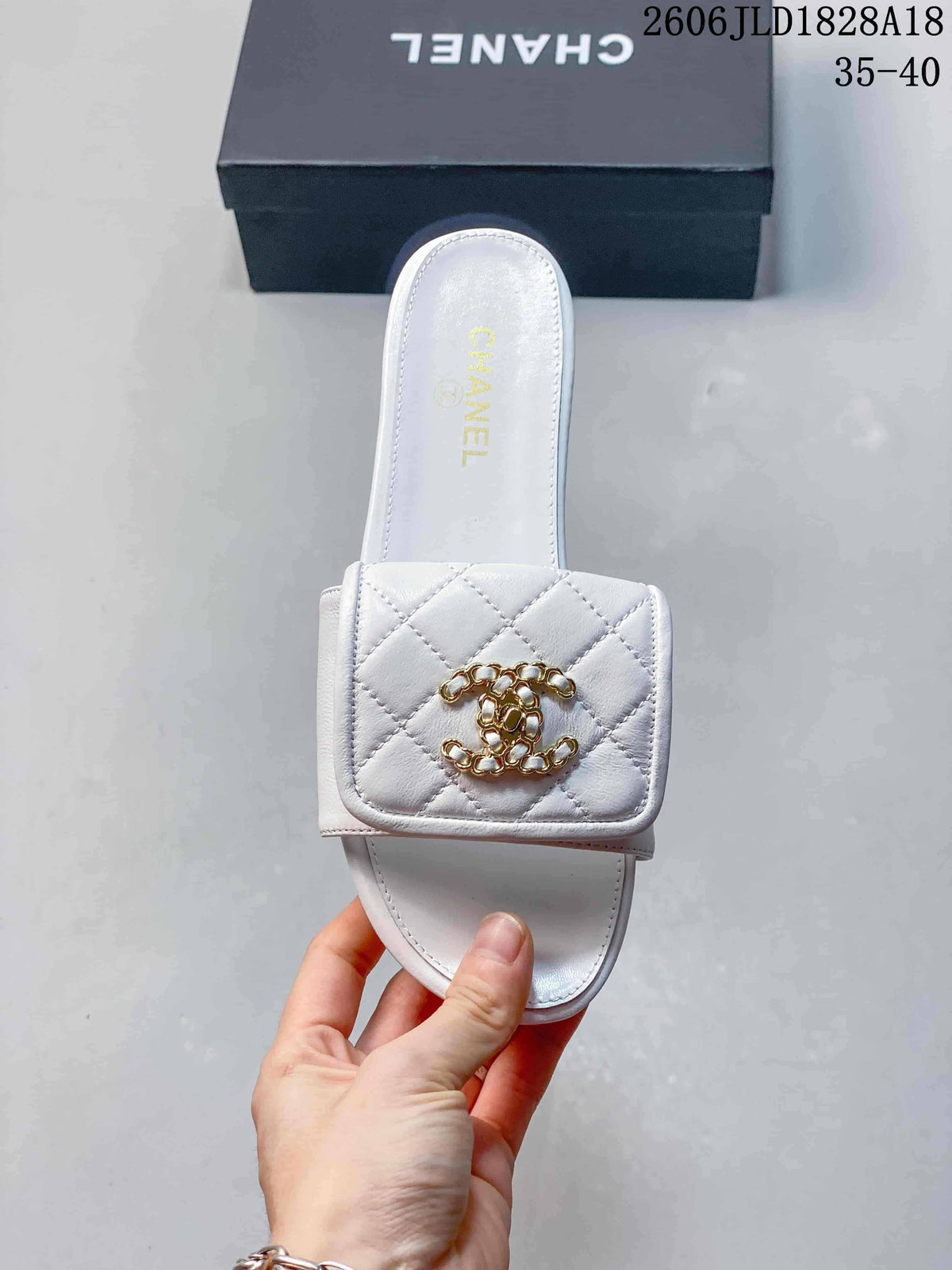 Top view of a white slide sandal with a square-front quilted strap and gold-tone Double C-style ornament.