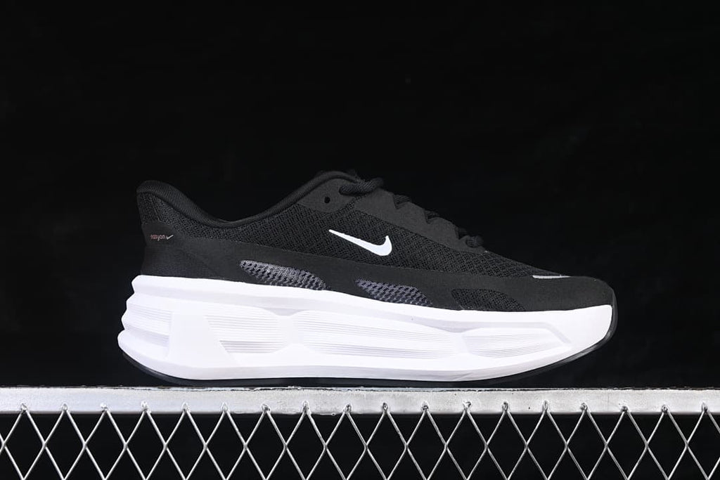 Side view of a black Nike Comfort Ride Easyon shoe with white Swoosh and thick white midsole.