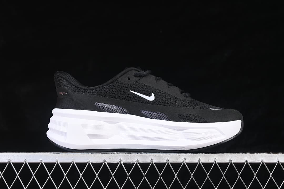 Side view of a black Nike Comfort Ride Easyon shoe with white Swoosh and thick white midsole.