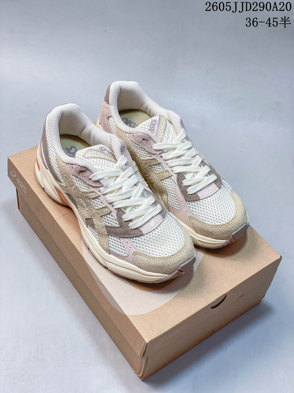 Pair of cream, taupe, and soft pink ASICS GEL-1130 sneakers shown on a shoebox.