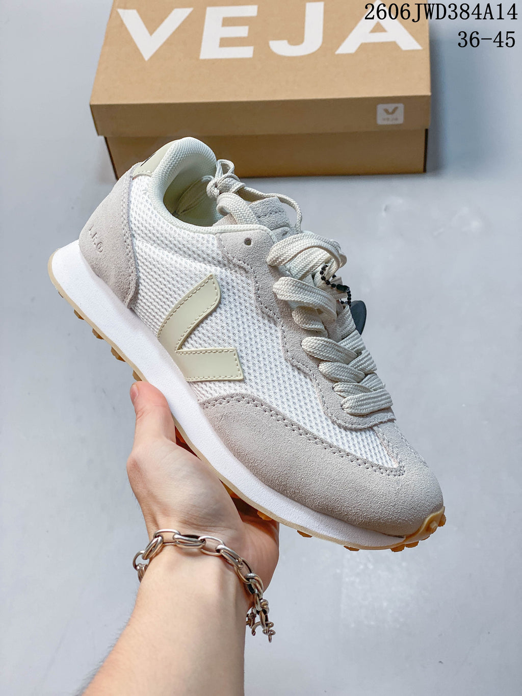 White and light-gray Veja sneaker with a pale V-shaped side logo and gum-colored outsole.