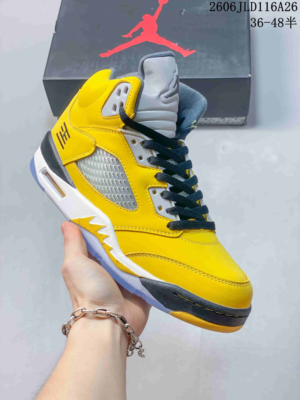 Side view of a yellow high-top sneaker with dark laces and gray accents