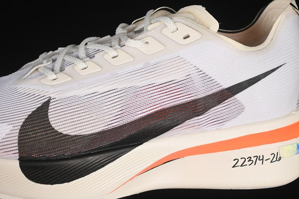 Close-up of the black Swoosh and orange midsole accent