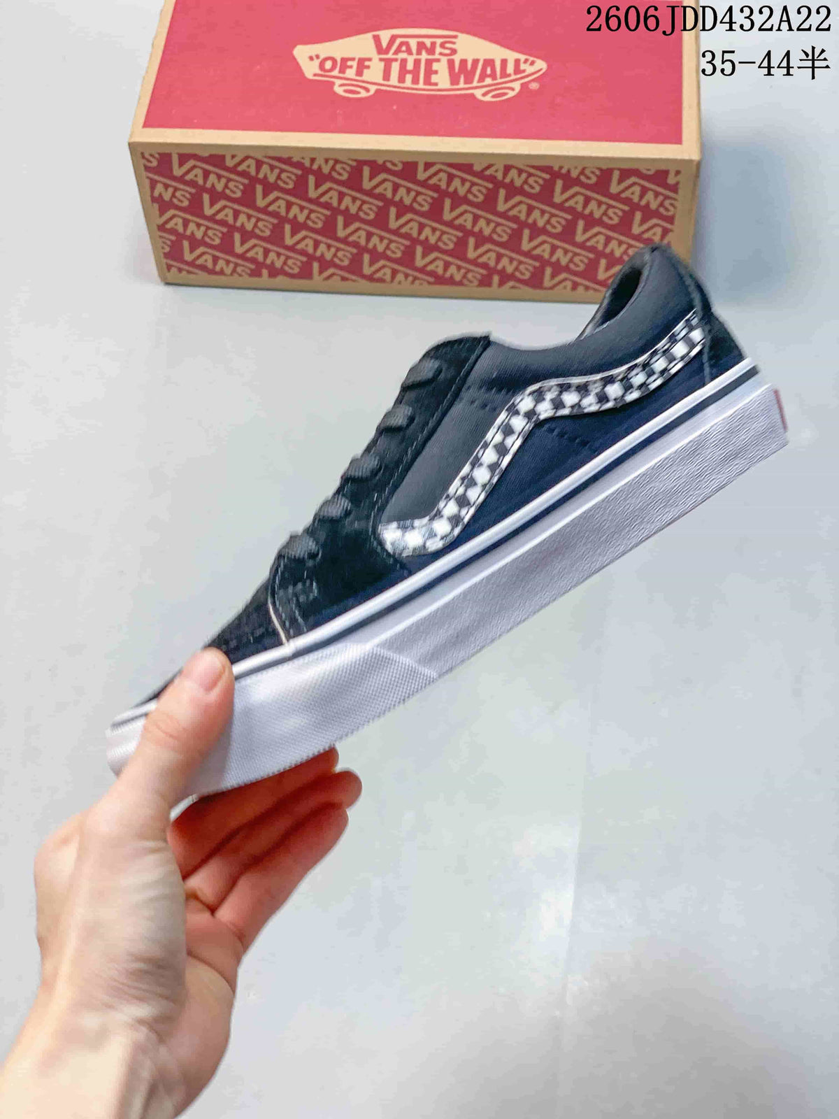 Side profile of a black Vans low-top sneaker with a checkerboard stripe