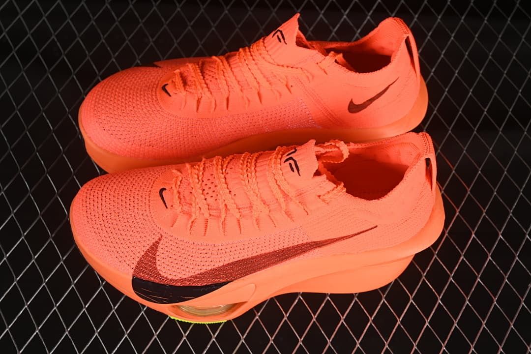 Pair of bright orange running shoes shown from above