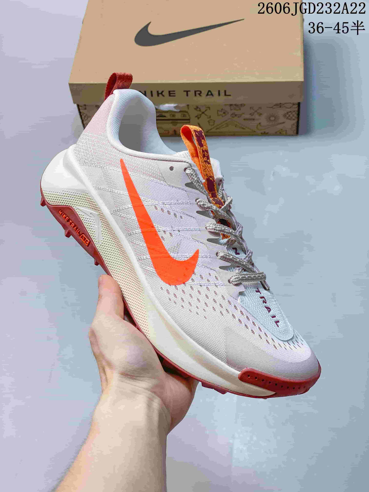 Side view of a light Nike Wildhorse 10 trail-running shoe with orange accents and a trail-style outsole.